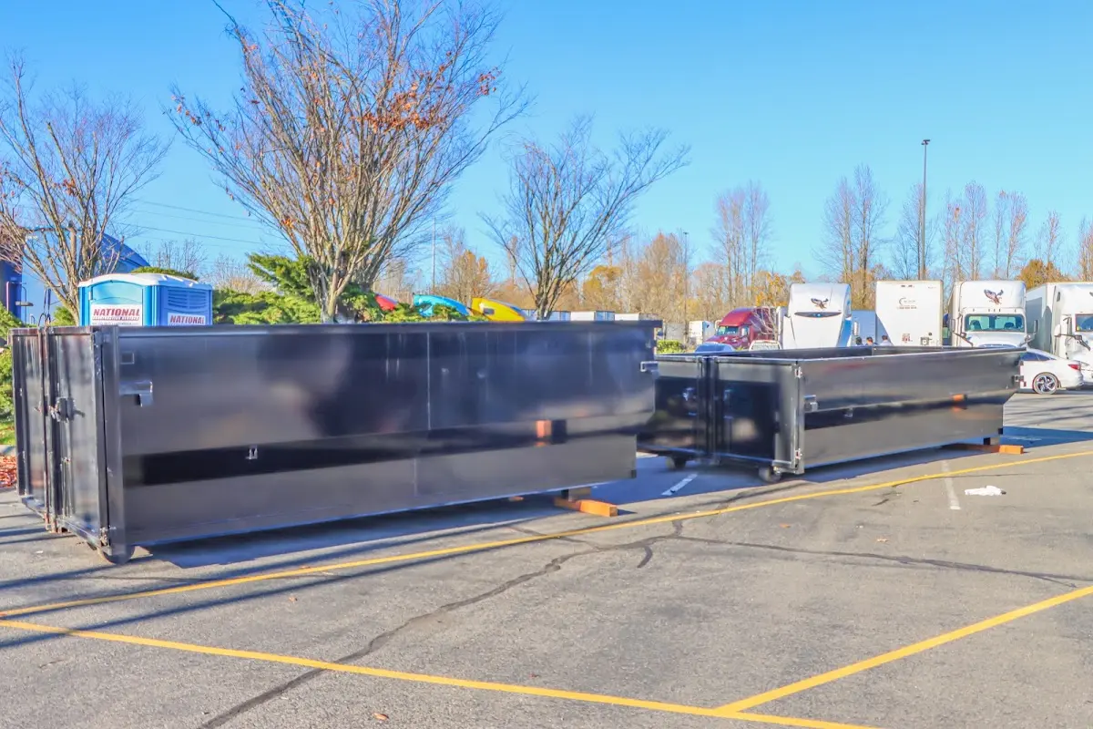 Professional dumpster rental service with roll-off container on residential driveway in Lowell